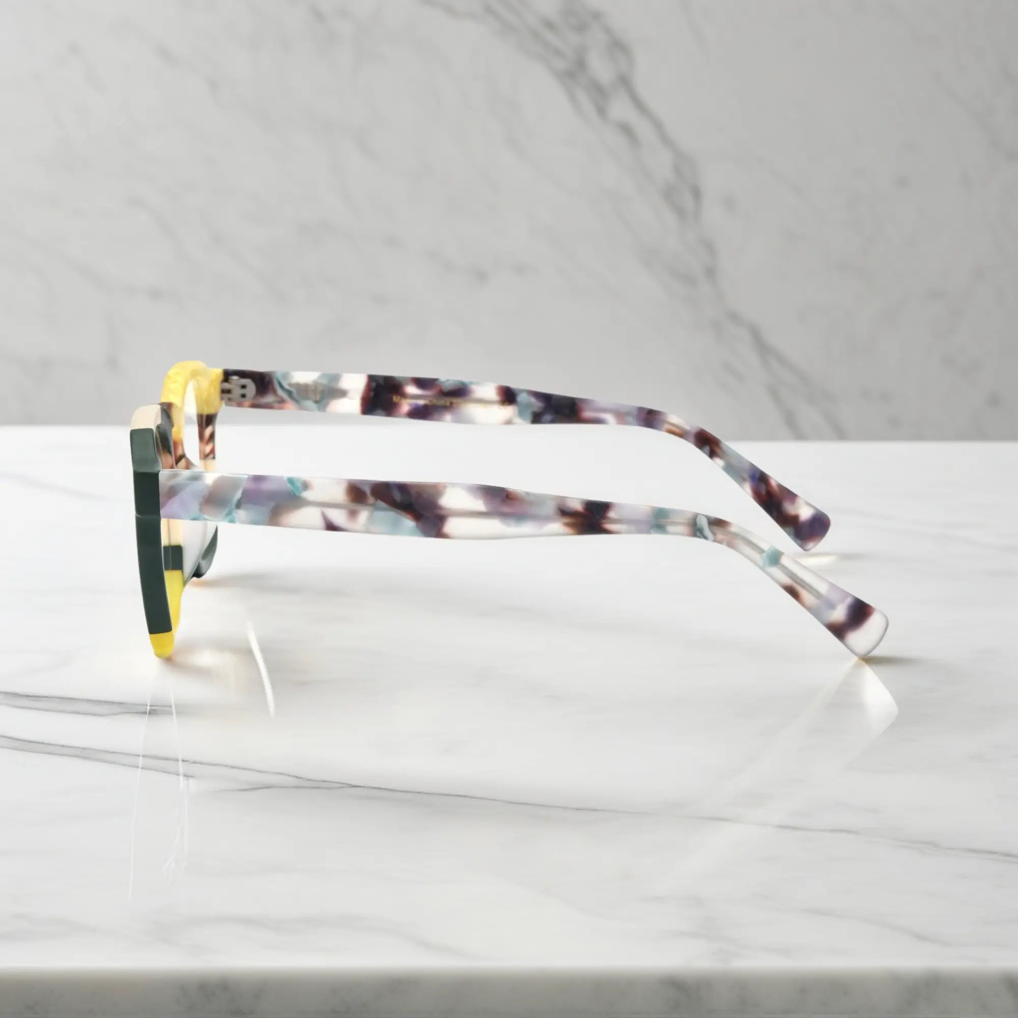 Angled close-up of VoyueLens™ VL19358 Citrus Fade square-glasses, capturing the gradient tones and stylish surface texture.